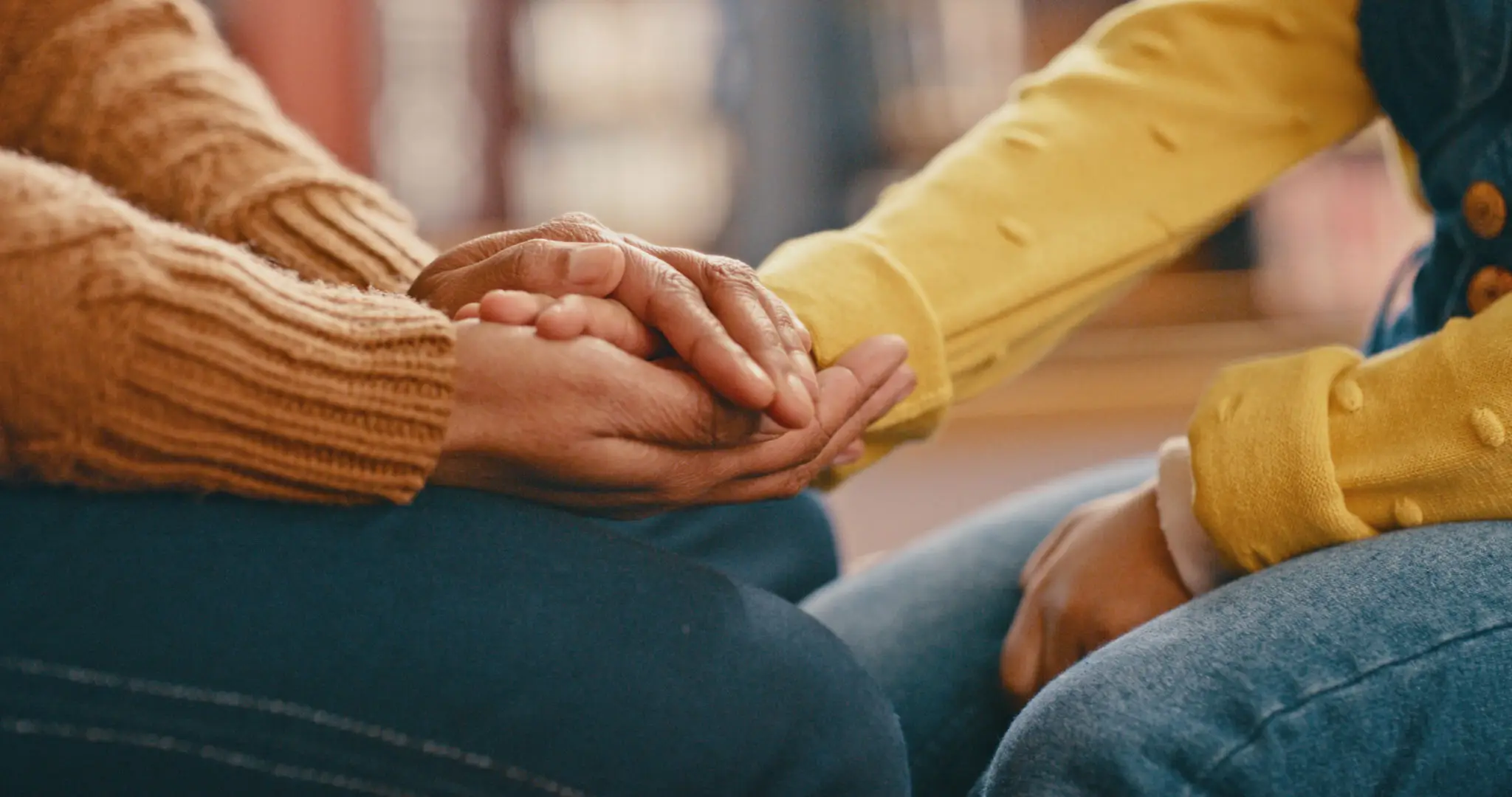 Two people holding hands in a comforting gesture.