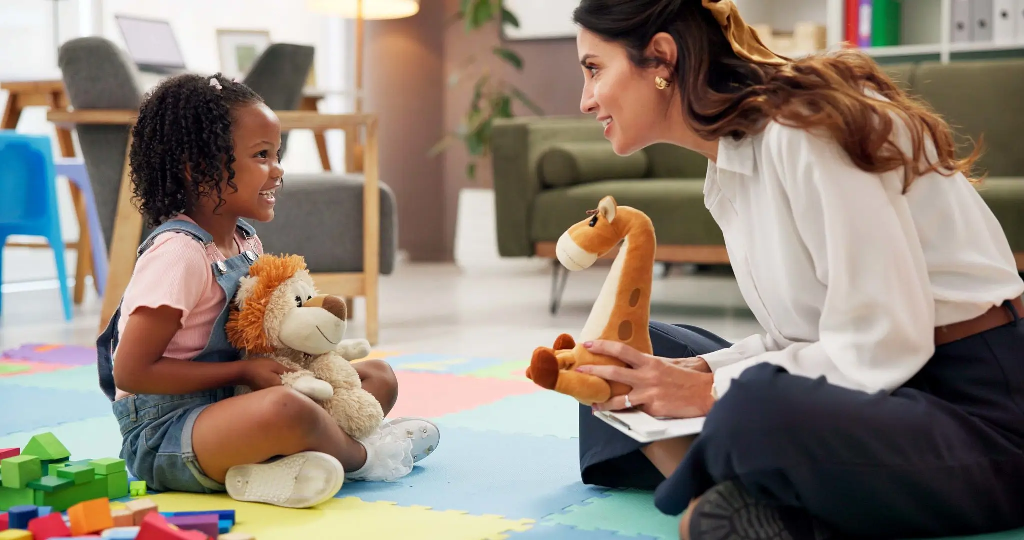 Teacher engaging with child on playmat