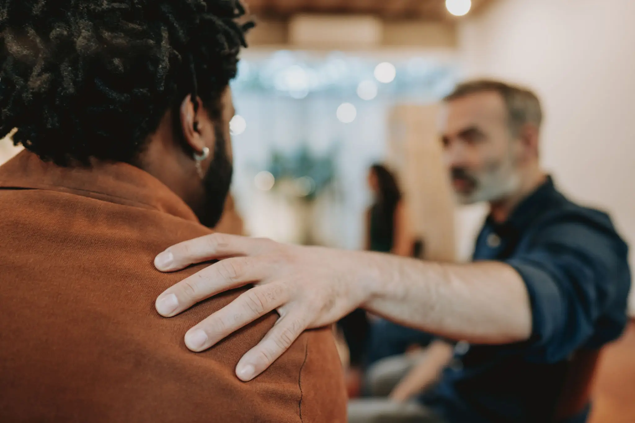 A comforting gesture between two people during a conversation.