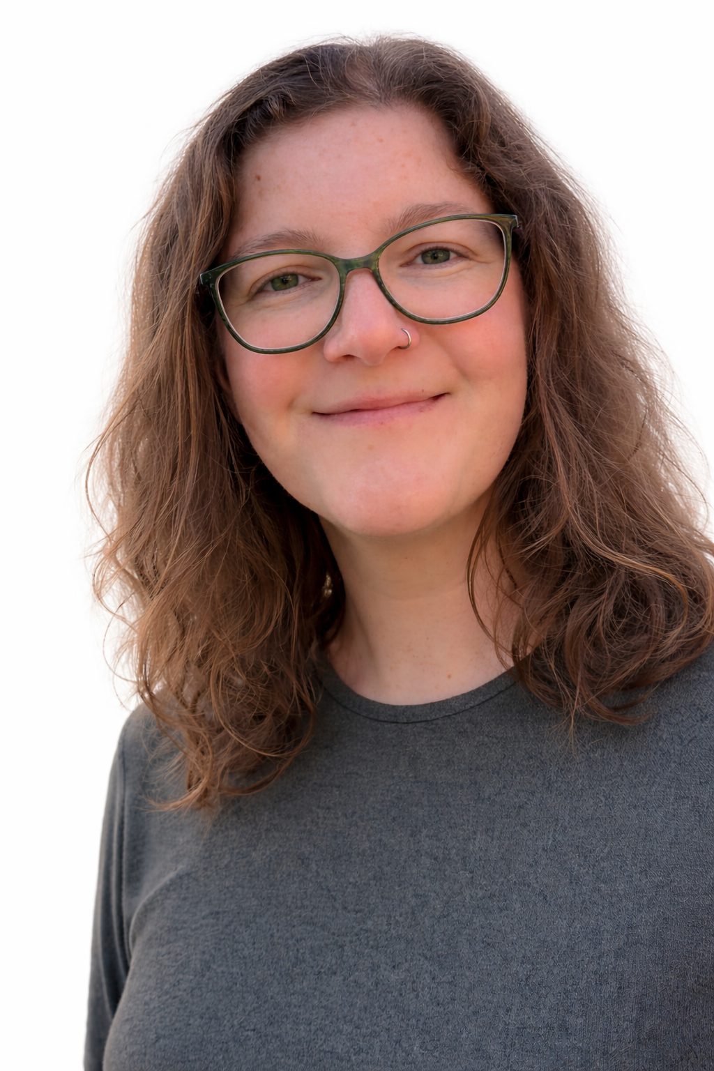 Smiling young woman with glasses and curly hair.