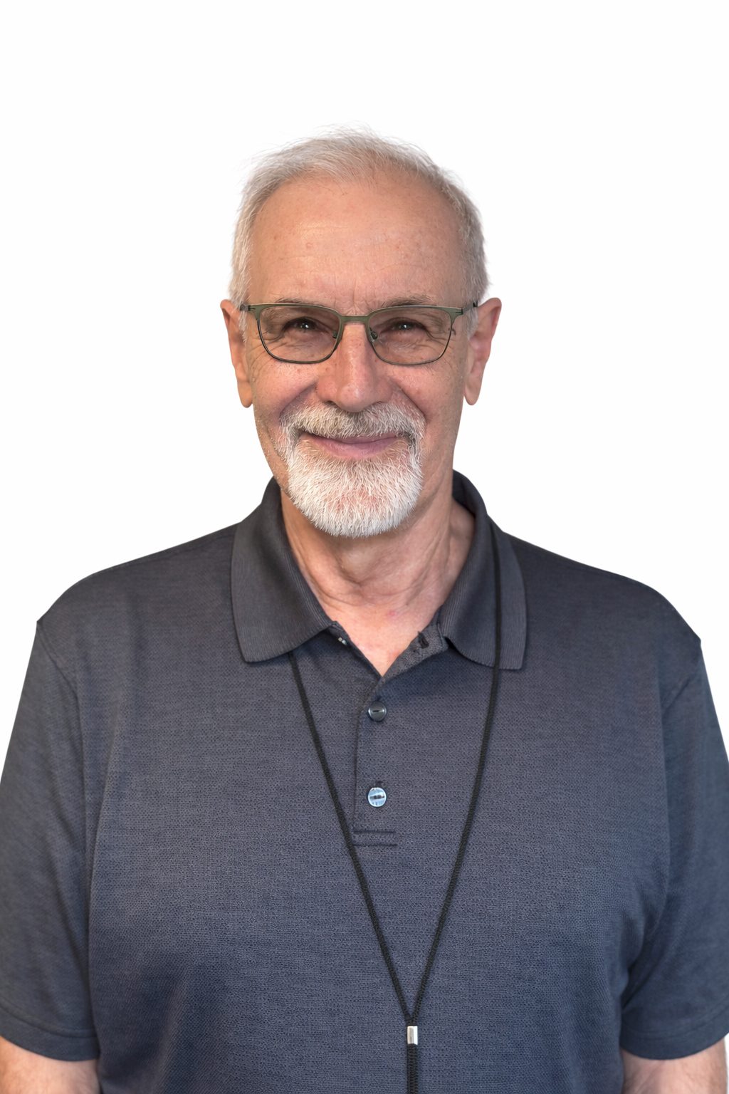 Smiling elderly man with glasses and a gray polo shirt.