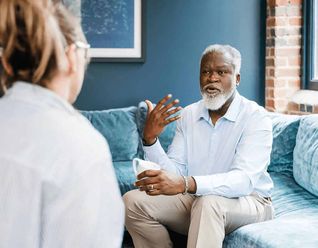 Senior man discussing with therapist in a counseling session.