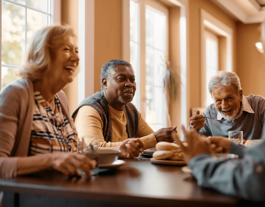 Seniors laughing together over a meal