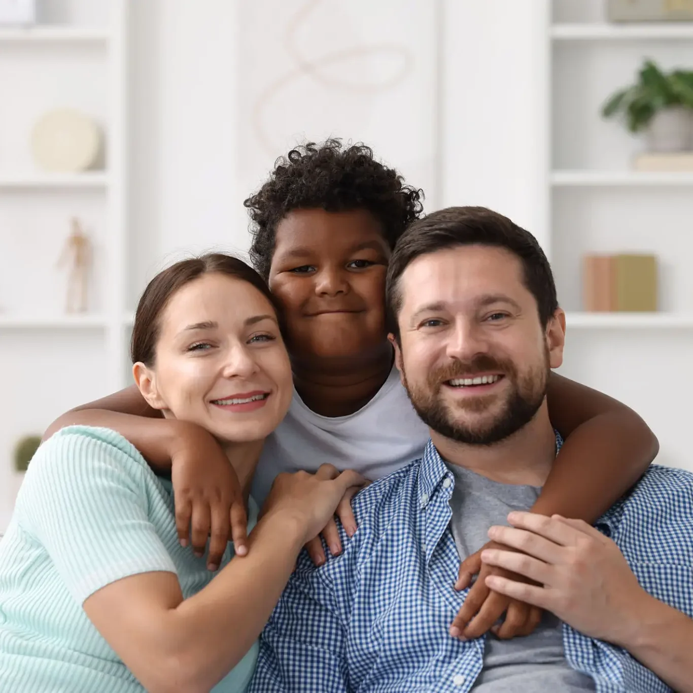 Happy family of three posing together with smiles.