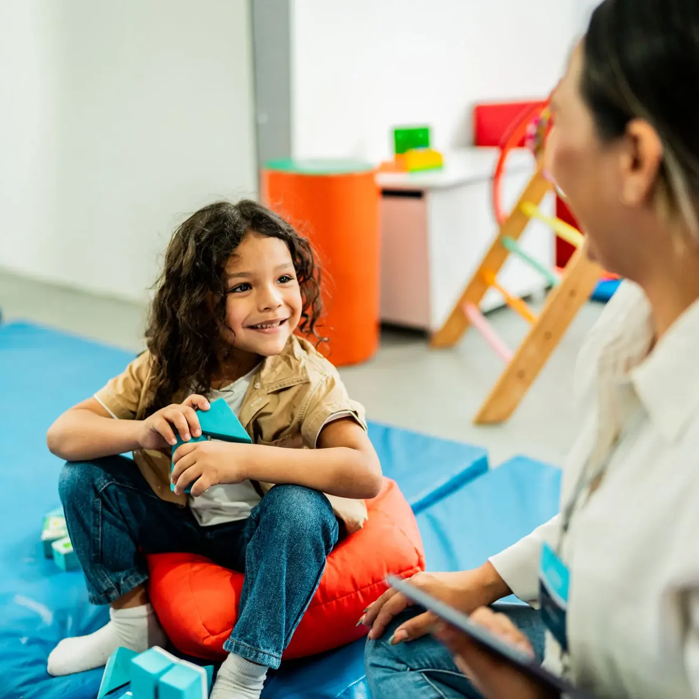 Smiling child interacting with adult indoors